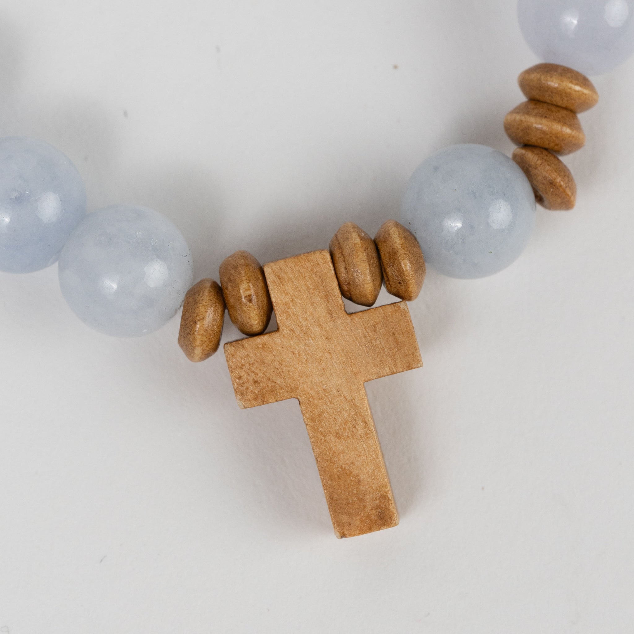 Bracelet stretch w/cross charm stn/wd lt blu/brn